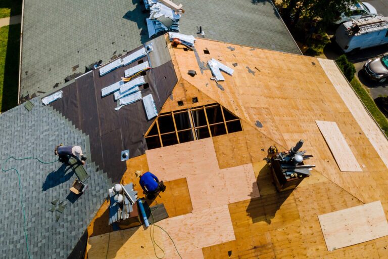 roofing contractors reviewing plans and materials at a job site, showcasing teamwork and professionalism.