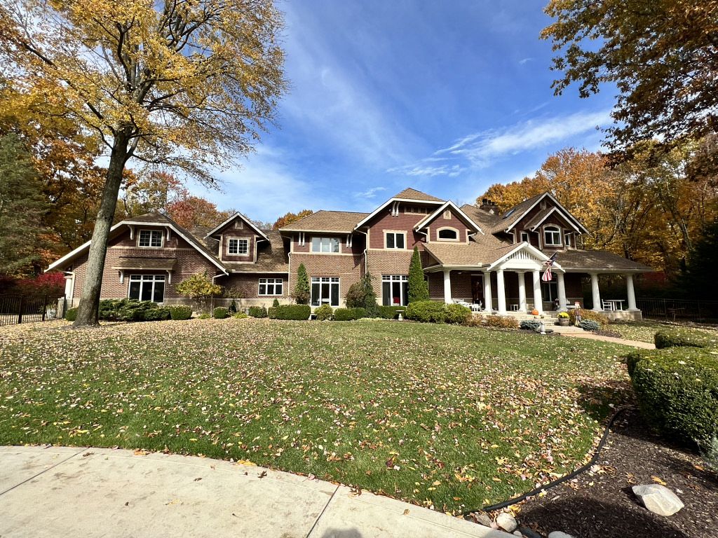 A large home featuring a spacious driveway and well-maintained lawn, showcasing a welcoming residential environment.