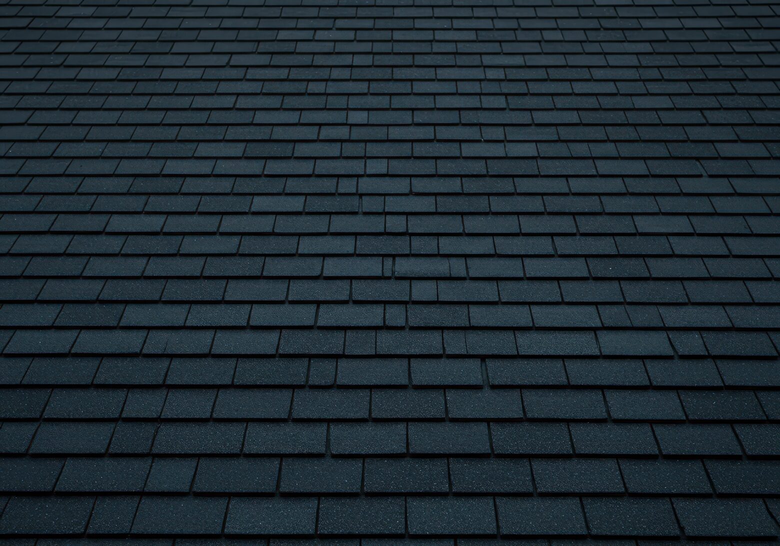 Rows of overlapping dark gray architectural shingles